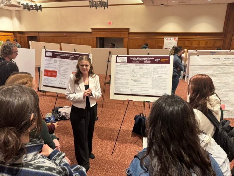 Bethany Thompson discussing her poster with students